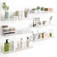 three clear shelves filled with different types of personal care items and plants on top of each shelf