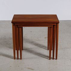 three small wooden tables sitting on top of a white floor next to eachother