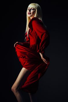 a woman in a red dress is posing for a photo with her hands on her hips