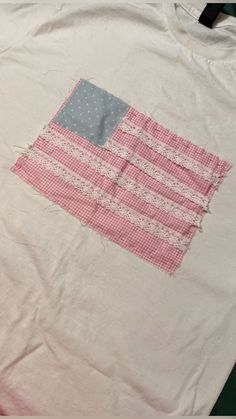 an american flag on a white t - shirt with pink and blue trimmings