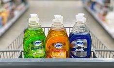 three bottles of detergent sitting in a shopping cart