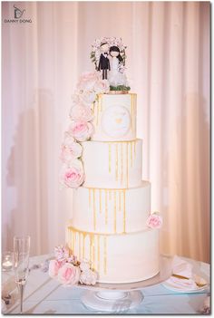 a three tiered wedding cake decorated with flowers and a bride and groom figurine