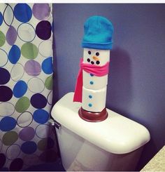 a toilet with a snowman decoration on the lid and cover over it's tank