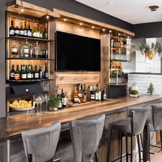 a bar with lots of bottles and glasses on top of it next to a flat screen tv