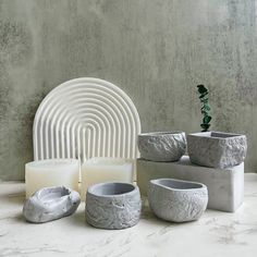 a group of white vases sitting next to each other on top of a table