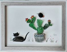 a cactus and a black cat in a white frame