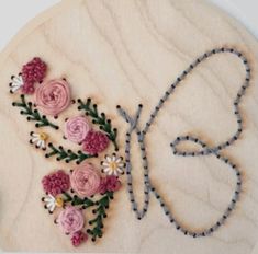 a wooden plaque with flowers on it and the word love spelled in cursive writing