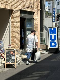 a man walking down the street carrying shopping bags