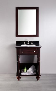 a bathroom vanity with a mirror above it and two towels on the shelf under it