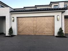 a white house with two wooden garage doors