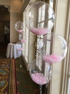 three bubble balls are hanging from the ceiling in front of a table with white linens