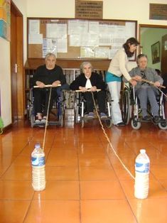 a group of people in wheelchairs sitting on the floor with ropes attached to them