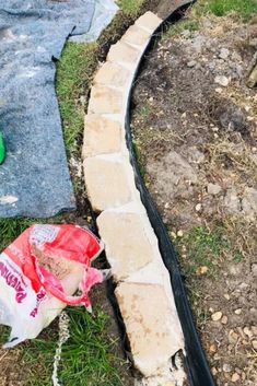 an empty bag sitting on the ground next to a garden hose and some dirt in front of it