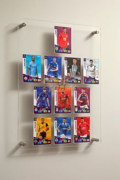 a wall mounted display with soccer cards on it's glass frame and magnets attached to the back of each card