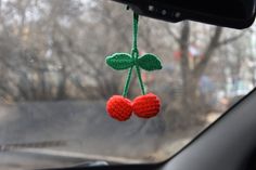 two cherries are hanging from the dashboard of a car