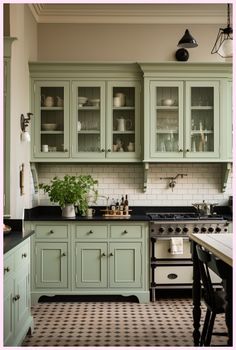 a kitchen with lots of green cabinets and black counter tops on top of a checkered floor