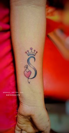 a woman's foot with a heart and crown tattoo on her left ankle,