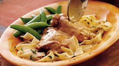 a wooden bowl filled with pasta and meat