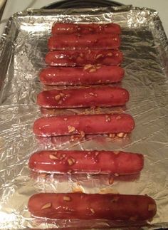 four sausages on tin foil lined up in rows