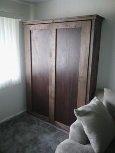 a living room with a couch and wooden closet