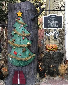 a christmas tree is on display in front of a sign