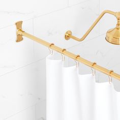 a white shower curtain next to a gold handle on a wall mounted faucet