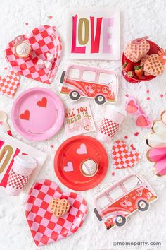 valentine's day table setting with plates, cups and utensils on white fabric