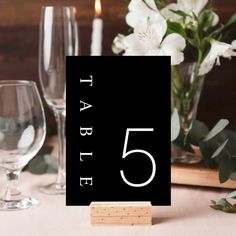 the table numbers are placed next to wine glasses