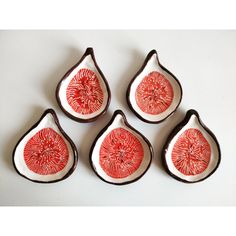 four red and white dishes sitting on top of a table