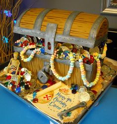 a birthday cake made to look like a pirate's chest with beads and decorations