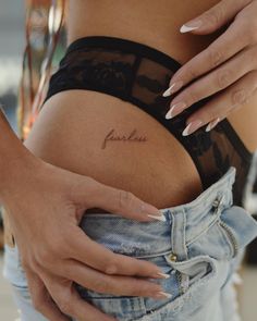 a woman's stomach with the word fearless tattooed on her lower belly and bottom