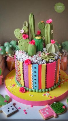 a cake decorated with cactus and flowers on a table