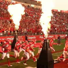 the football team is running down the field with flarers in their hands as they run onto the field