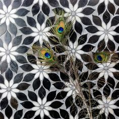 two peacock feathers are sitting on top of a flower arrangement in front of a black and white background