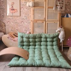 a child's bedroom with a green futon and rocking chair