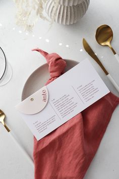 a place setting with napkins and gold spoons