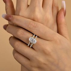 a woman's hand with two engagement rings on it