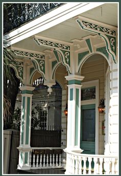 the front porch of an old house with green and white trim