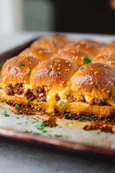 a cheesy sandwich with cheese and meat is on a baking sheet, ready to be eaten