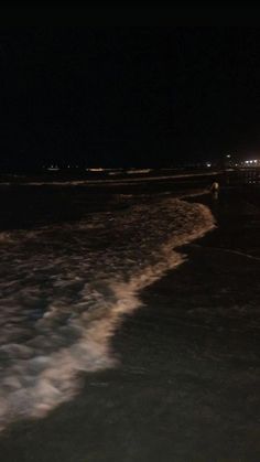 a person riding skis on top of a body of water in the dark at night