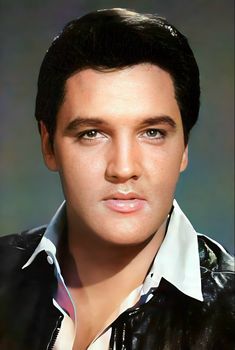 a close up of a person wearing a black leather jacket and white collared shirt