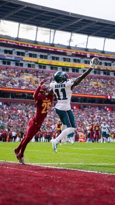 two football players jumping in the air during a game