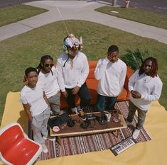 a group of people sitting on top of a couch in front of a red object