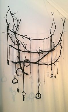 a bunch of keys hanging from a tree branch with scissors attached to it's branches