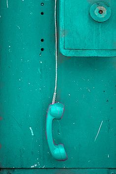 a pink phone is hanging on the side of a metal wall with holes in it