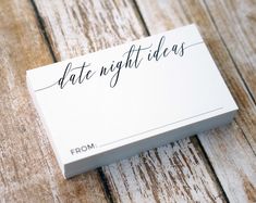 a white business card with the word date night ideas on it sitting on a wooden table