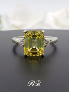 a fancy yellow diamond ring sitting on top of a table