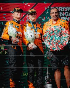 three men standing next to each other holding bottles and confetti on their hands