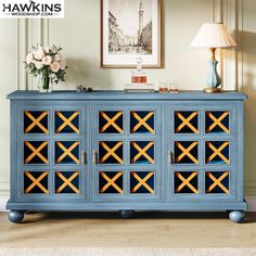 an image of a blue sideboard with geometric designs on the front and sides, in a living room setting