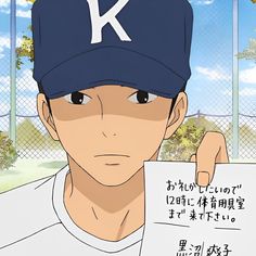 a baseball player holding up a sign with the letter k on it